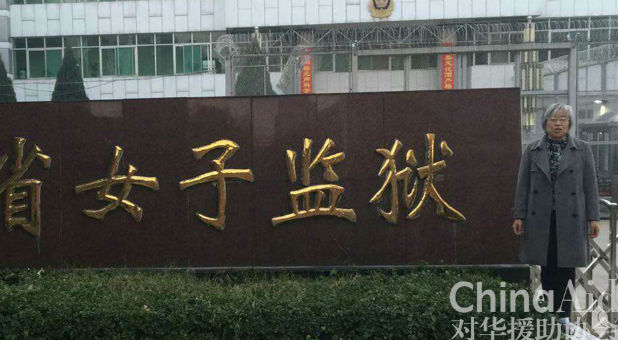 Yang Rongli poses next to a sign for Shanxi Women's Prison, where she was incarcerated. (