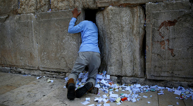 A man clears notes placed in the cracks of the Western Wall, Judaism's holiest prayer site, to clear space for new notes ahead of the Jewish New Year, in Jerusalem's Old City