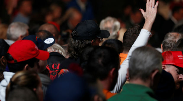 Supporters bow their heads in prayer as they gather to rally with Republican U.S. presidential nominee Donald Trump at an arena in Manchester, New Hampshire.