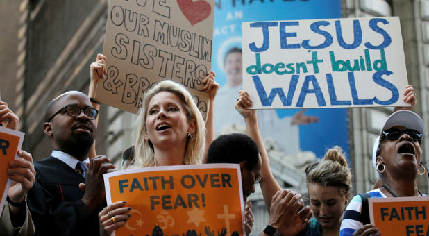 A group of interfaith religious leaders protest against Republican presidential candidate Donald Trump outside a hotel where he was to meet with evangelical leaders in New York City