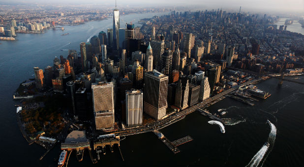 The rising sun lights One World Trade as it stands over the Manhattan borough of New York.