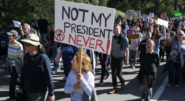 A woman holds a sign during a protest against President-elect Donald Trump at Golden Gate Park in San Francisco