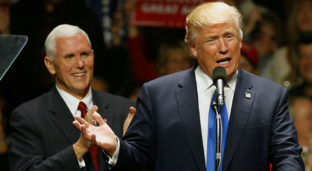 Republican U.S. presidential nominee Donald Trump and vice presidential nominee Mike Pence (L) rally with supporters at an arena in Manchester, New Hampshire.