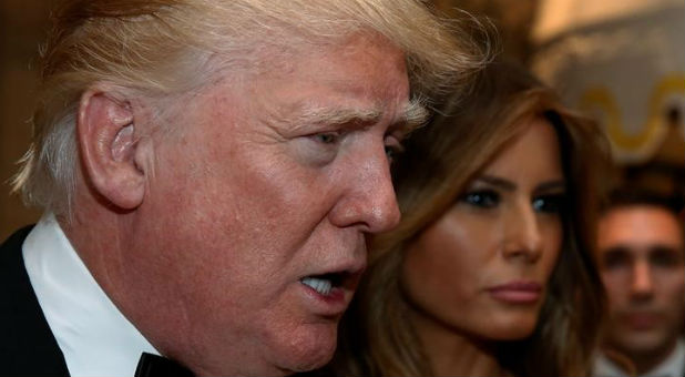 U.S. President-elect Donald Trump talks to reporters as he and his wife, Melania Trump, arrive for a New Year's Eve celebration