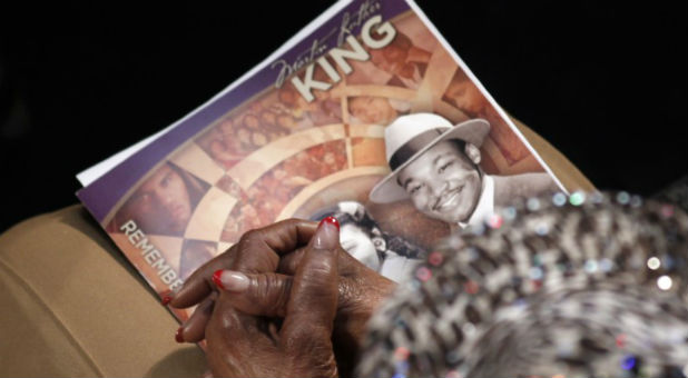 A visitor holds a commemorative booklet as she listens during the Martin Luther King Jr. 46th Annual Commemorative Service at Ebenezer Baptist Church