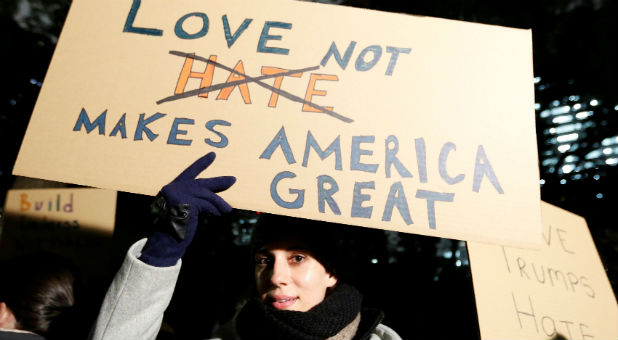 A woman holds an anti U.S. President-elect Donald Trump placard during a rally in Tokyo, Japan