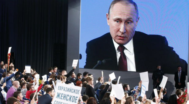 Journalists listen to Russian President Putin during his annual end-of-year news conference in Moscow