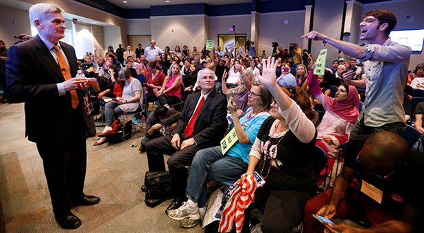 U.S. Sen. Bill Cassidy (R-La.) and Indivisible protesters