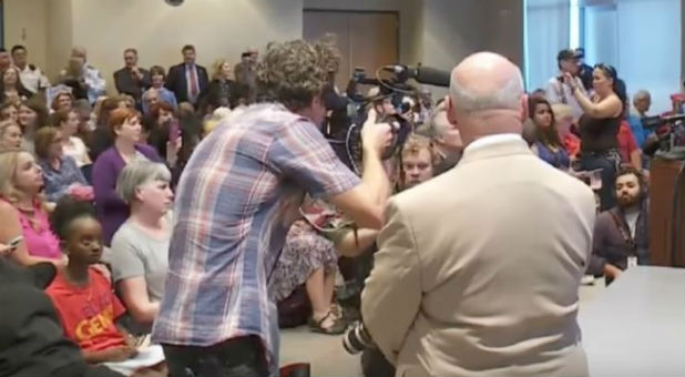 People protest at a Town Hall event.