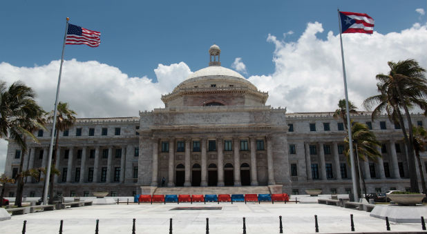 The flags of the U.S. and Puerto Rico fly outside the Capitol building in San Juan, Puerto Rico.