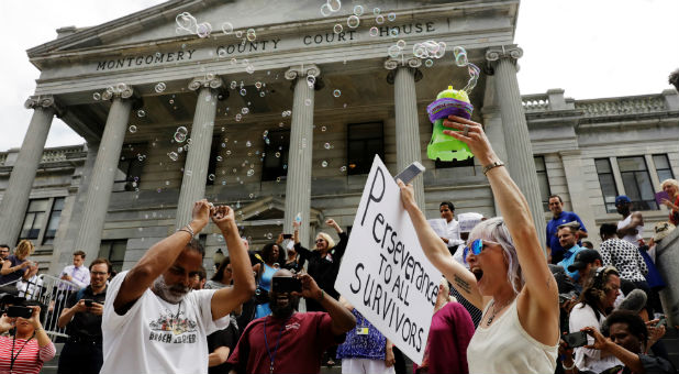 Bird Milliken carries a sign as she demonstrates in support of victims of sexual violence outside the Montgomery County Courthouse where Bill Cosby is waiting for deliberations to finish in his sexual assault trial.