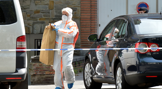 Belgian policemen get out of a house after searching it, following yesterday's attack, in Brussels, Belgium.