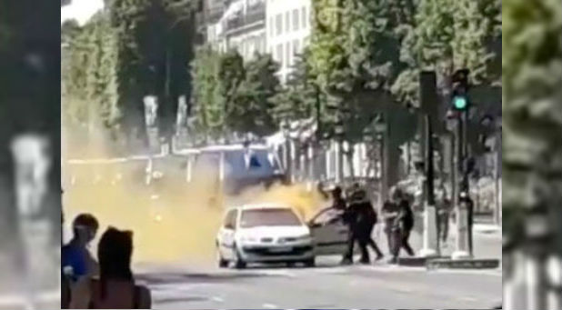 French police officers engage with a suspect outside a car at the Champs Elysees avenue in Paris, France.