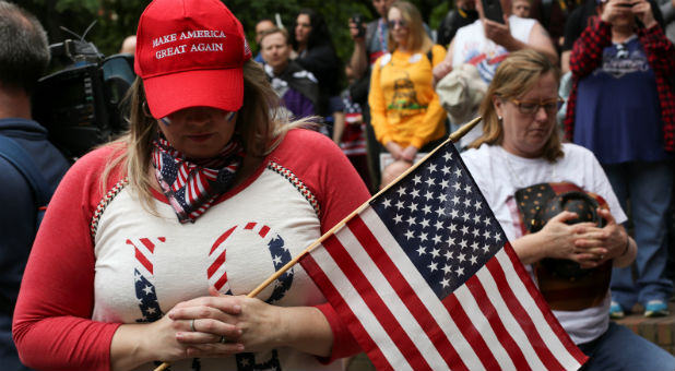 Protesters listen during the national anthem at the Trump Free Speech Rally in Portland, Oregon.