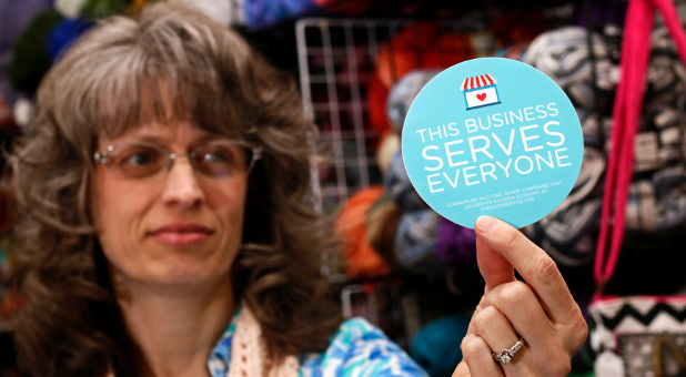 Elizabeth Ladd, owner of River Knits Fine Yarns, poses while holding up a