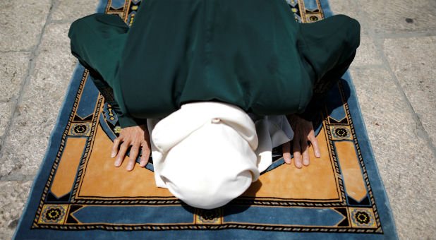 A Palestinian woman prays outside the compound known to Muslims as Noble Sanctuary and to Jews as Temple Mount, just outside Jerusalem's Old City.