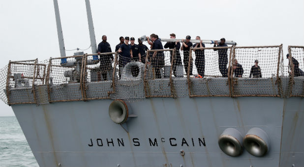 Personnel work on the U.S. Navy guided-missile destroyer USS John S. McCain after a collision, in Singapore waters Aug. 21, 2017.