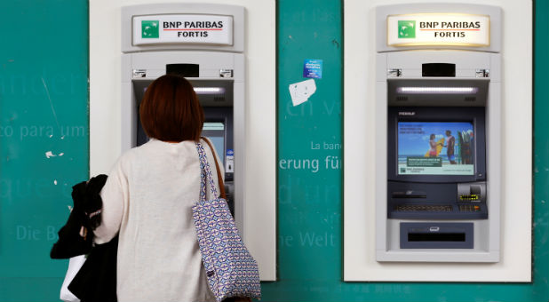 A woman withdraws cash at an ATM.