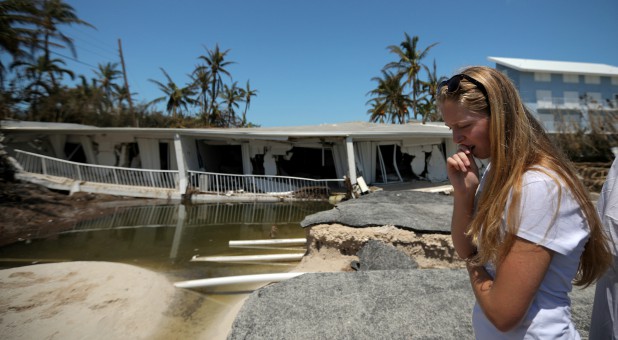 A woman evaluates her damaged home after Irma tore through.