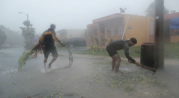 People pick up debris as Hurricane Irma howls past Puerto Rico.