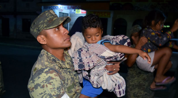 A soldier rescues a child in Mexico.