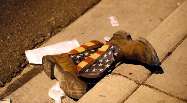 A pair of cowboy boots is shown in the street outside the concert venue.