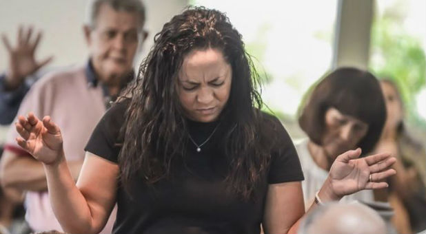 A woman worships during the prayer breakfast.