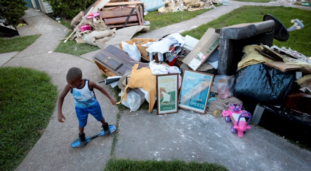 A little boy plays besides water-damaged items from his home.