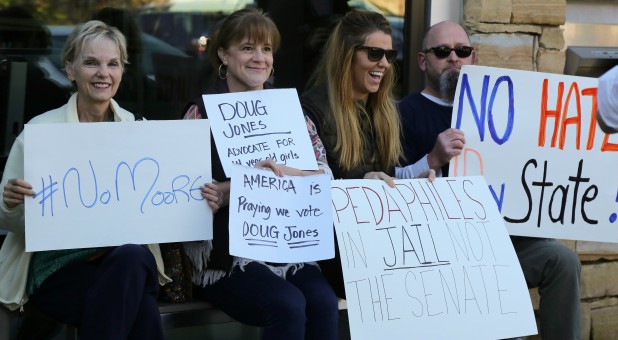 Protesters await Judge Roy Moore outside the Mid-Alabama Republican Club's Veterans Day Program in Vestavia Hills, Alabama.