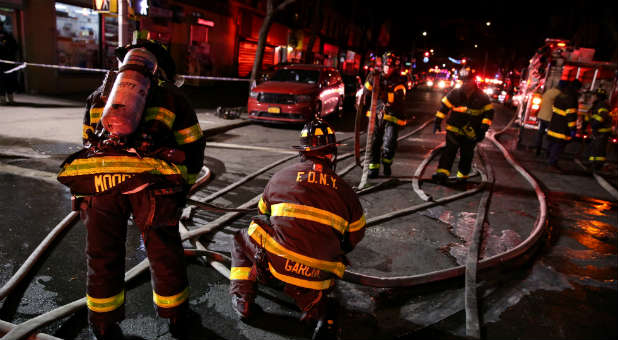 Fire Department of New York (FDNY) personnel work on the scene of an apartment fire in Bronx, New York.