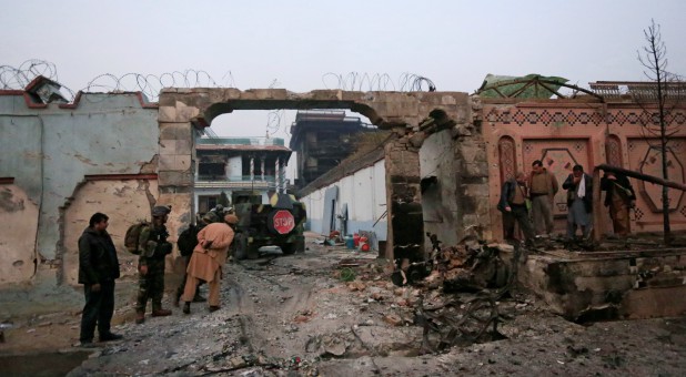 Afghan officials inspect the entrance gate of Save the Children Aid group in Afghanistan.