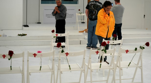 People react as they look at chairs showing where the Holcolmbe family and others were found dead at the First Baptist Church of Sutherland Springs.