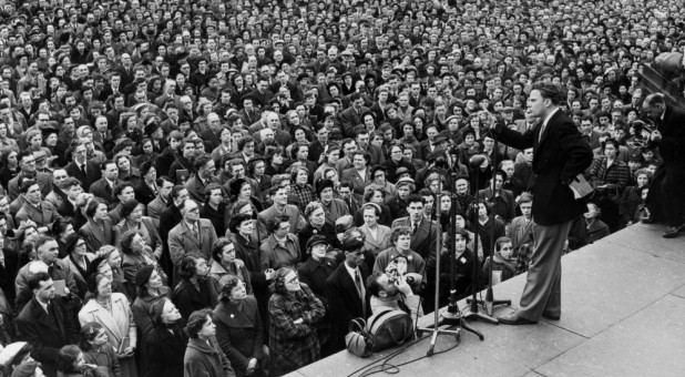 Billy Graham preaches at a crusade.