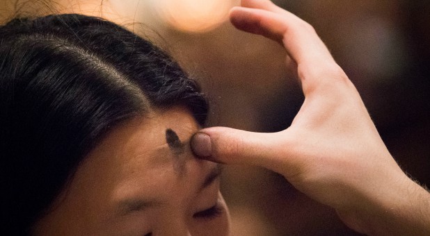 A woman receives ashes.