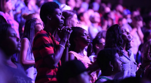 Attendees pray at a Harvest Crusade.