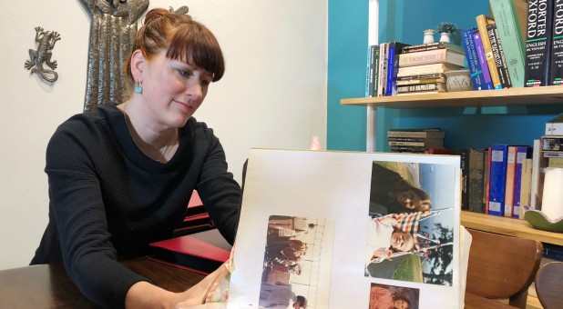 Molly Phinney Baskette, looks through a photo album of pictures of her brother, American cameraman and filmmaker, Jesse Phinney.