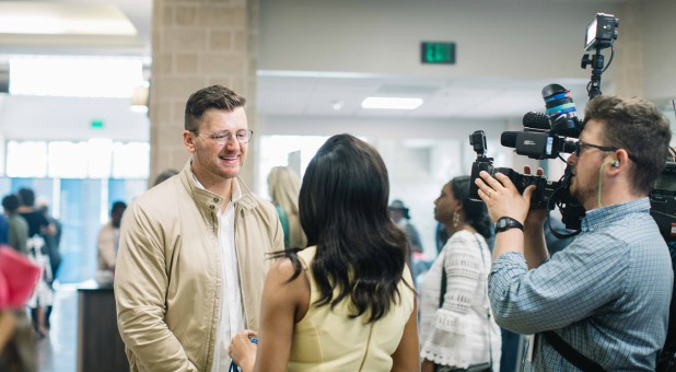 Stephen Hayes discusses the church's donation with a local news crew.