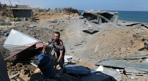 A Palestinian man inspects a destroyed Islamic Jihad military base after it was targeted by an Israeli warplane.