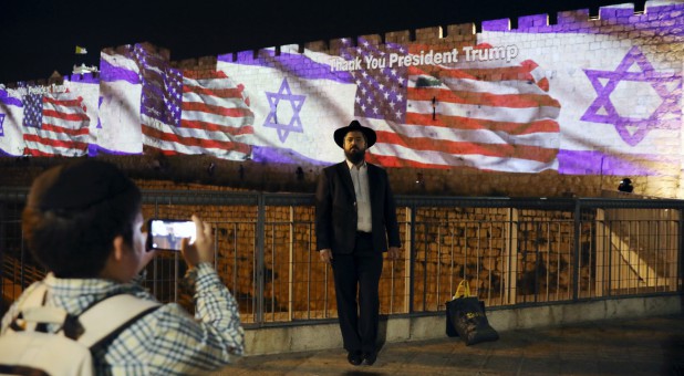 People take pictures of the U.S. and Israeli national flags as projected on a part of the walls surrounding Jerusalem's Old City.