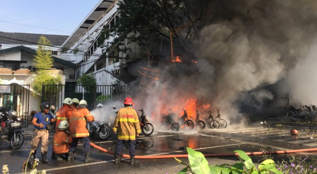 Firefighters try to extinguish a blaze following a blast at the Pentecost Church Central Surabaya (GPPS), in Surabaya, East Java, Indonesia.