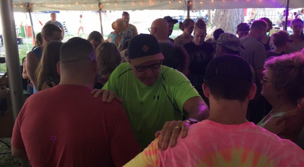 Larry Tomczak, center, prays.