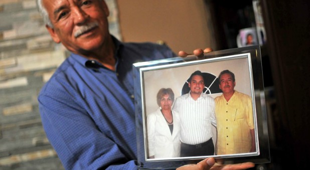 Eduardo Garcia, photographed in March 2017, holding a picture of his wife Maria and son Abraham, who was killed in 2009.