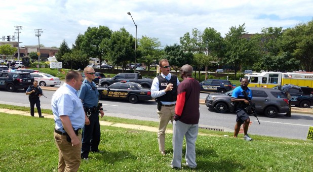 Police officers talk to a man as they respond to an active shooter inside a city building in Annapolis, Maryland