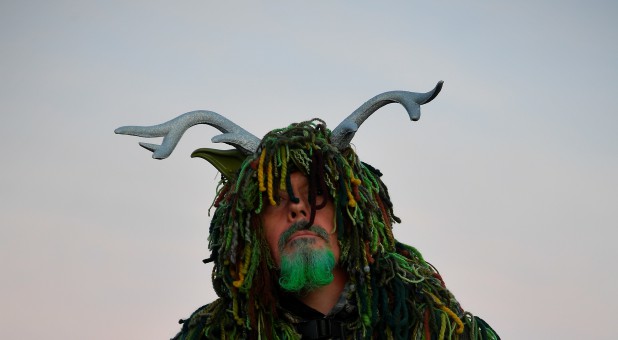 A reveler waits to welcome in the Summer Solstice at Stonehenge stone circle in southwest Britain.