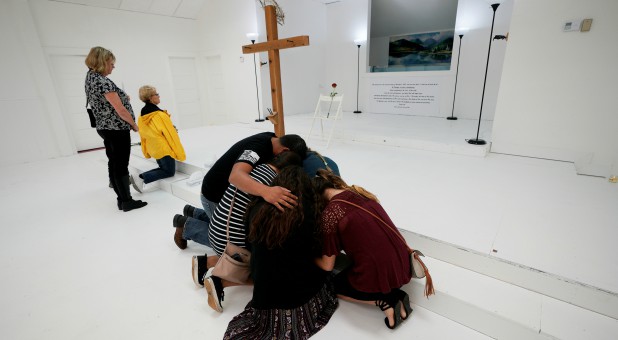 People pray in the First Baptist Church of Sutherland Springs, where 26 people were killed in a shooting attack in November.