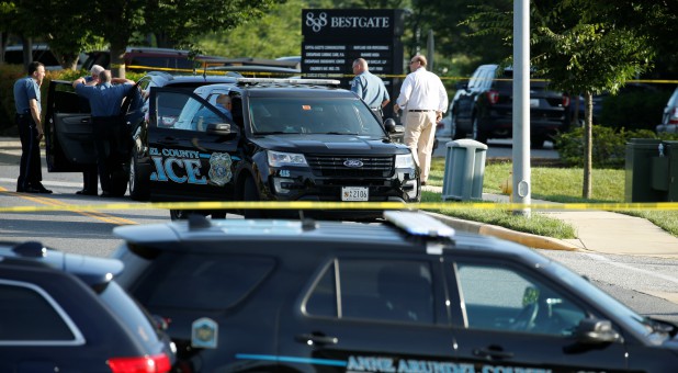 Police cars block the road in front of the Capital Gazette a day after a gunman opened fire at the newspaper's offices, killing five people and injuring several others in Annapolis, Maryland.