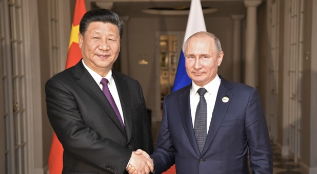 Russia's President Vladimir Putin (R) shakes hands with China's President Xi Jinping during a meeting.