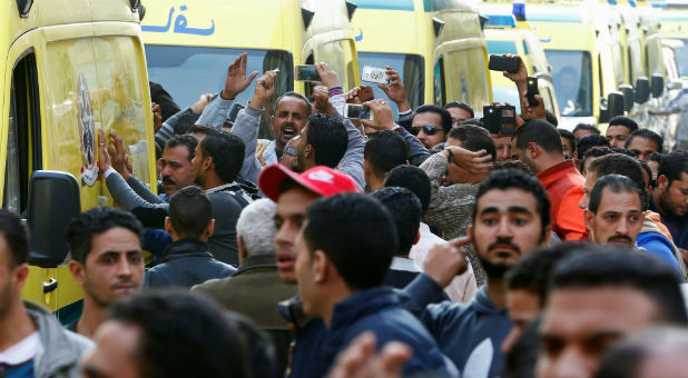 Egyptian Christians shout slogans as ambulances transport the bodies of victims killed in the bombing of Cairo's main Coptic cathedral after the funeral.