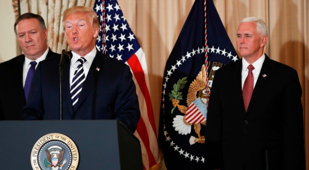 Donald Trump, center, speaks, while Mike Pence, right, looks on.