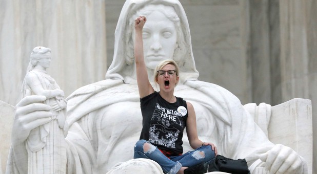 A protester sits on the lap of